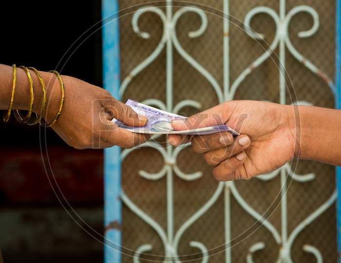 Close Up Of Hands Indian Women Taking Money In Front Of The House.