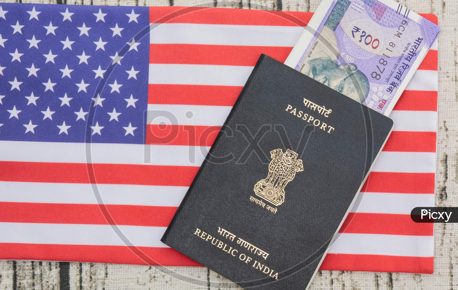Indian Passport With Currency On Usa Or America'S Flag As A Background
