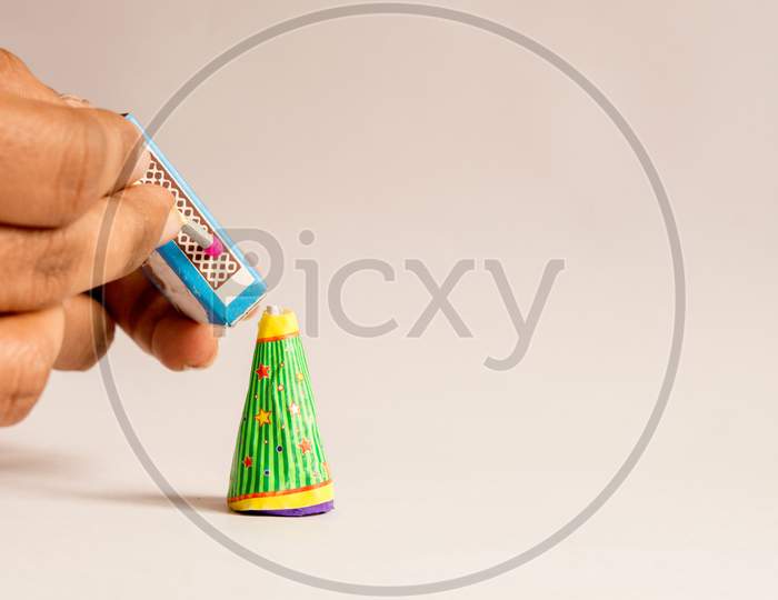 Burning Crackers With Hand Concept Using Matchstick On Isolated Background