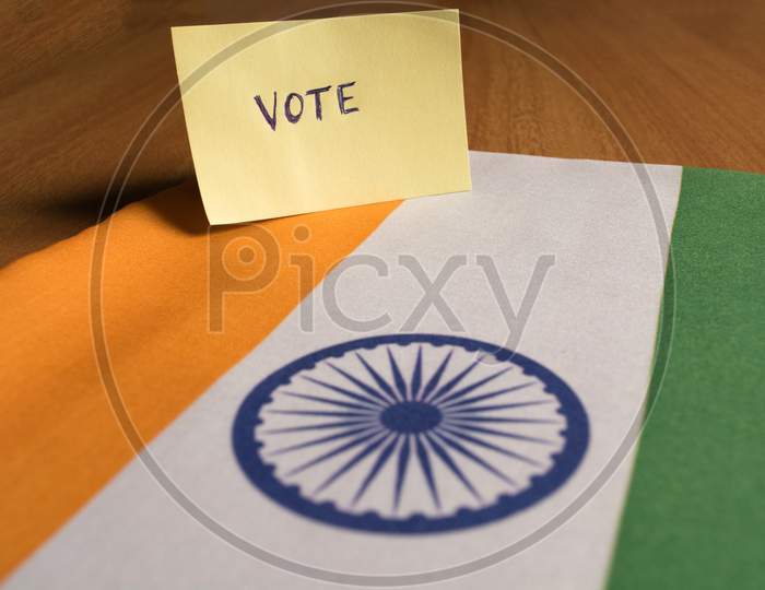 Voting Concept - Hand Written Voting Sticker On Indian Flag.