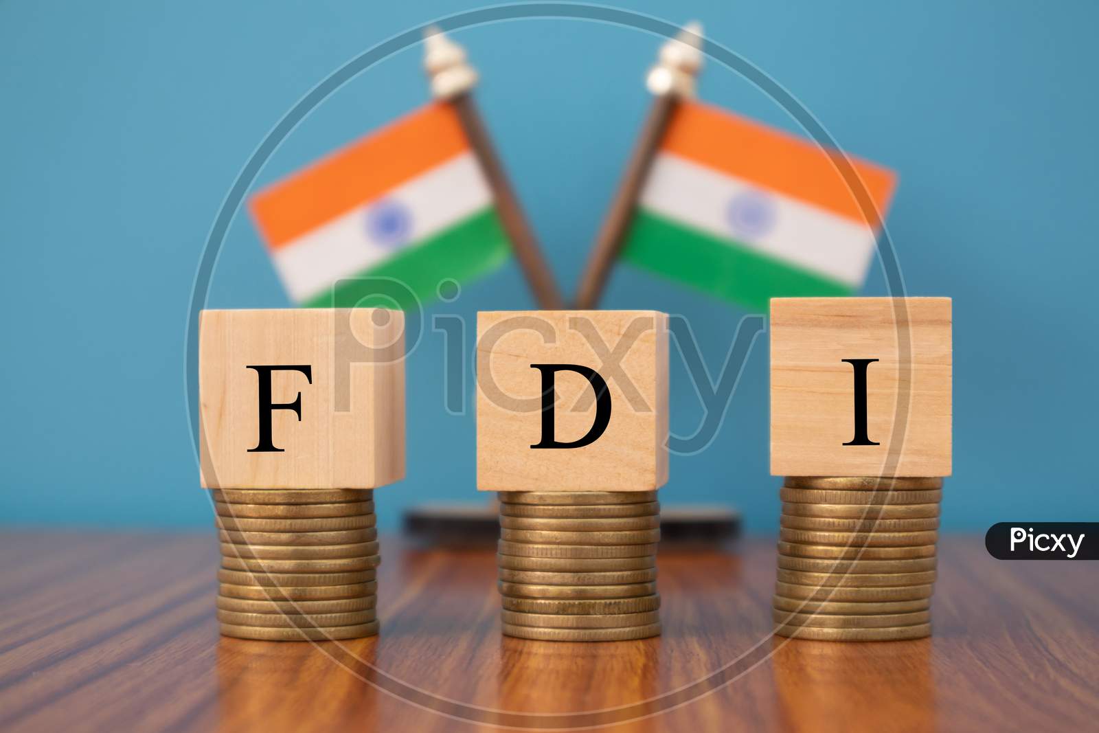 Concept Of Fdi Or Foreign Direct Investment On India In Wooden Block Letters On Stack Of Coins With Indian Flag As A Background.