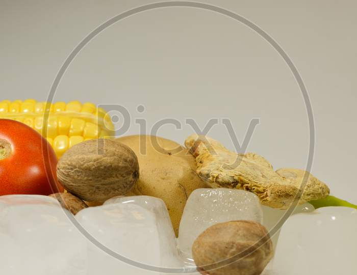 Tomato, Potato, Ginger, Corn and Chillies with the ice cubes isolated with white background