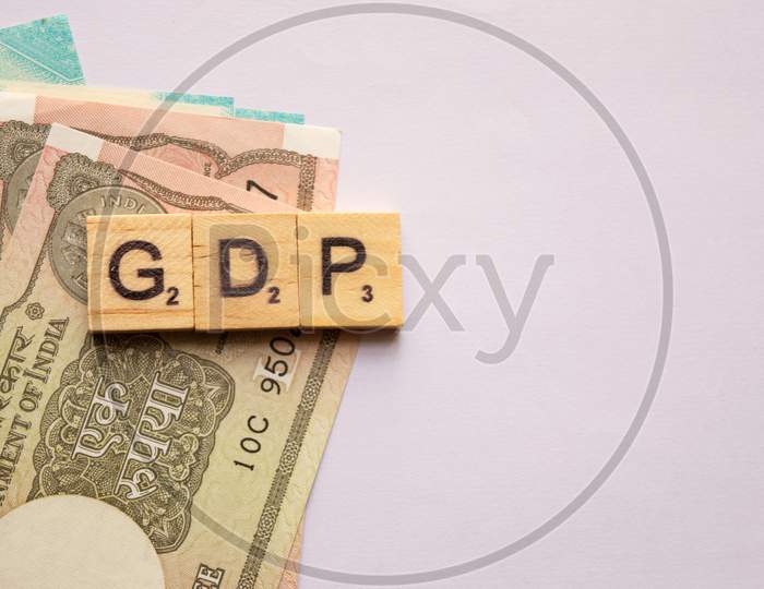 Gdp Or Gross Domestic Product In Wooden Block Letters With Indian Currency On Isolated Background.