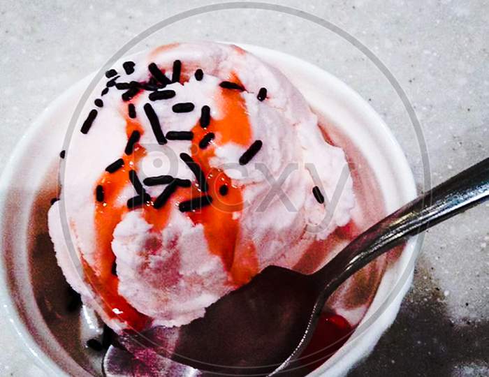 ice cream with sprinkles and cherry sauce