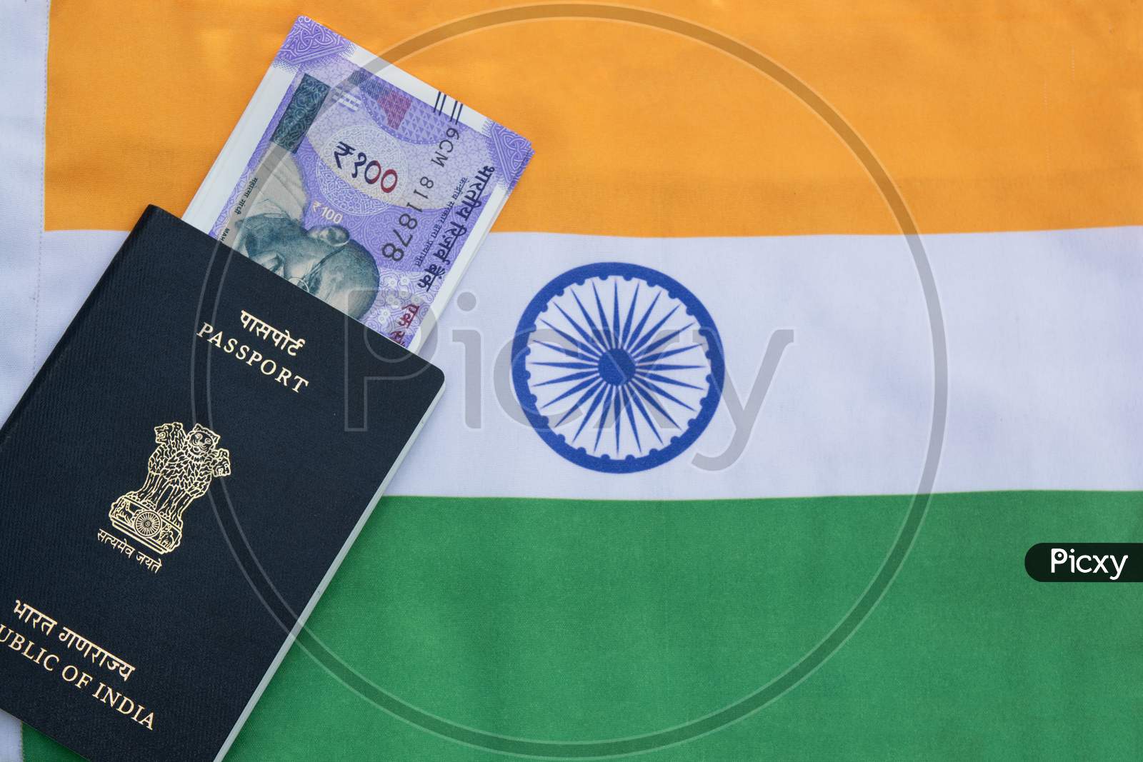 Closeup Of Indian Passport With Indian Currency On Indian Flag As A Background