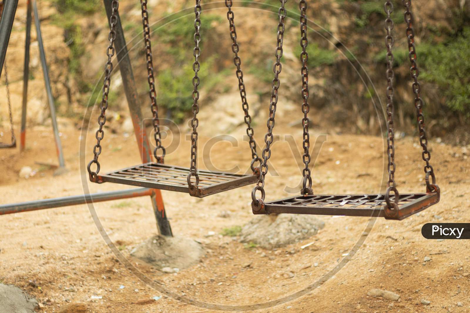Selective Focus Of Empty Spooky Swing In Desolate Park.