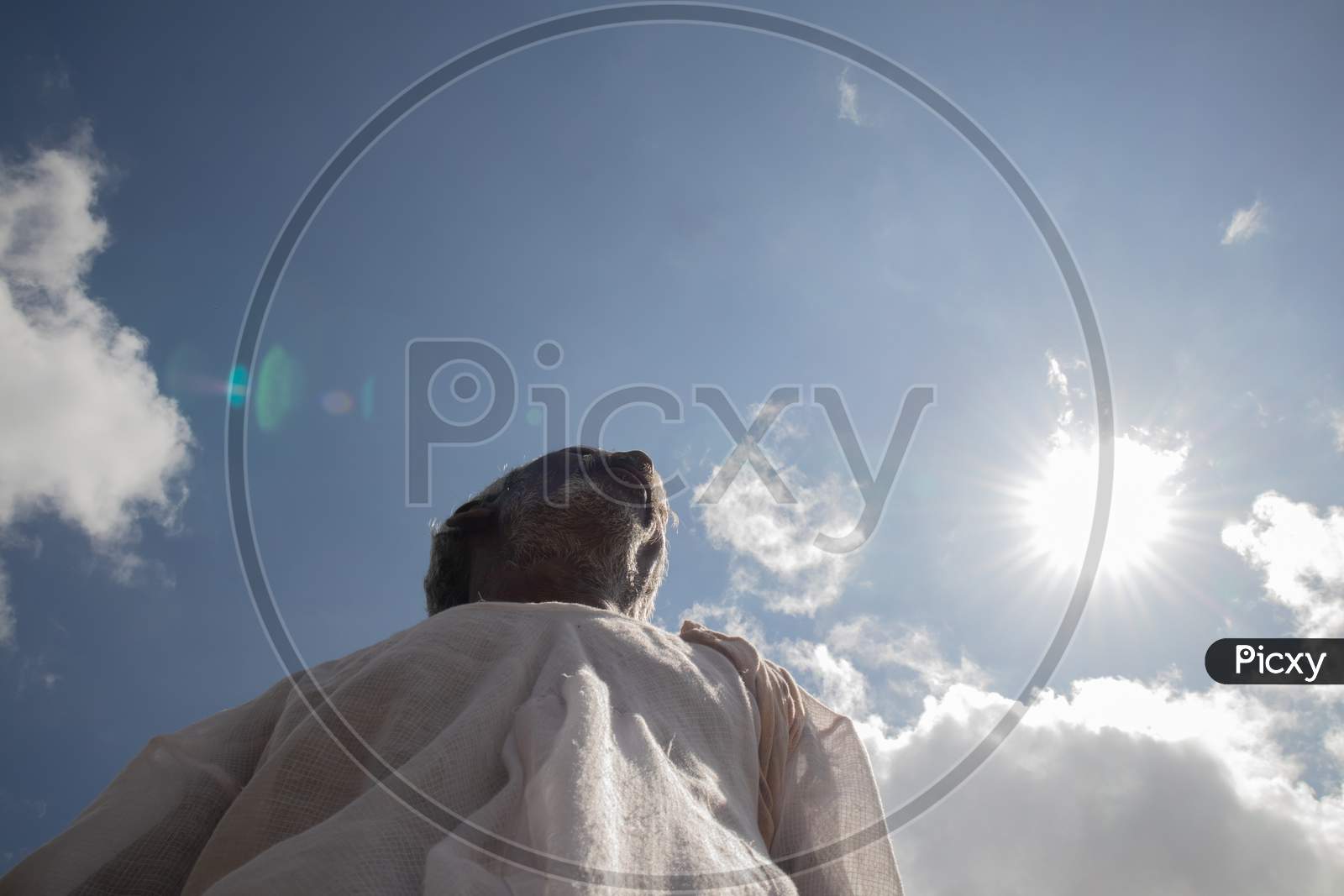 Low Angle View Of A Tribal Indian Farmer Below The Sun During Hot Sunny Day.