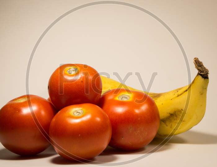 Tomatoes and Banana Isolated On A White Background.