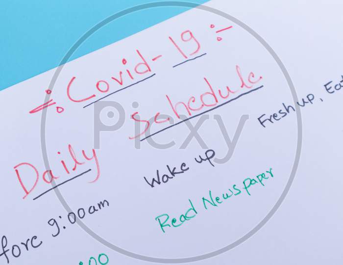 Concept Of Planning Daily Schedule During Covid-19 Or Coronavirus Lockdown Or Home Quarantine - Close Up Of Covid-19 Daily Schedule Planner Written On White Paper