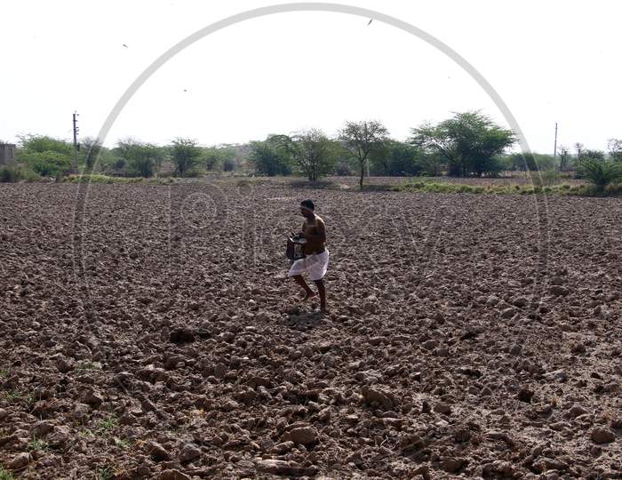 Villager Bang Pots In An Effort To Clear Locusts From Fields On The Outskirts Village Of Ajmer, Rajasthan, India On 07 June 2020.