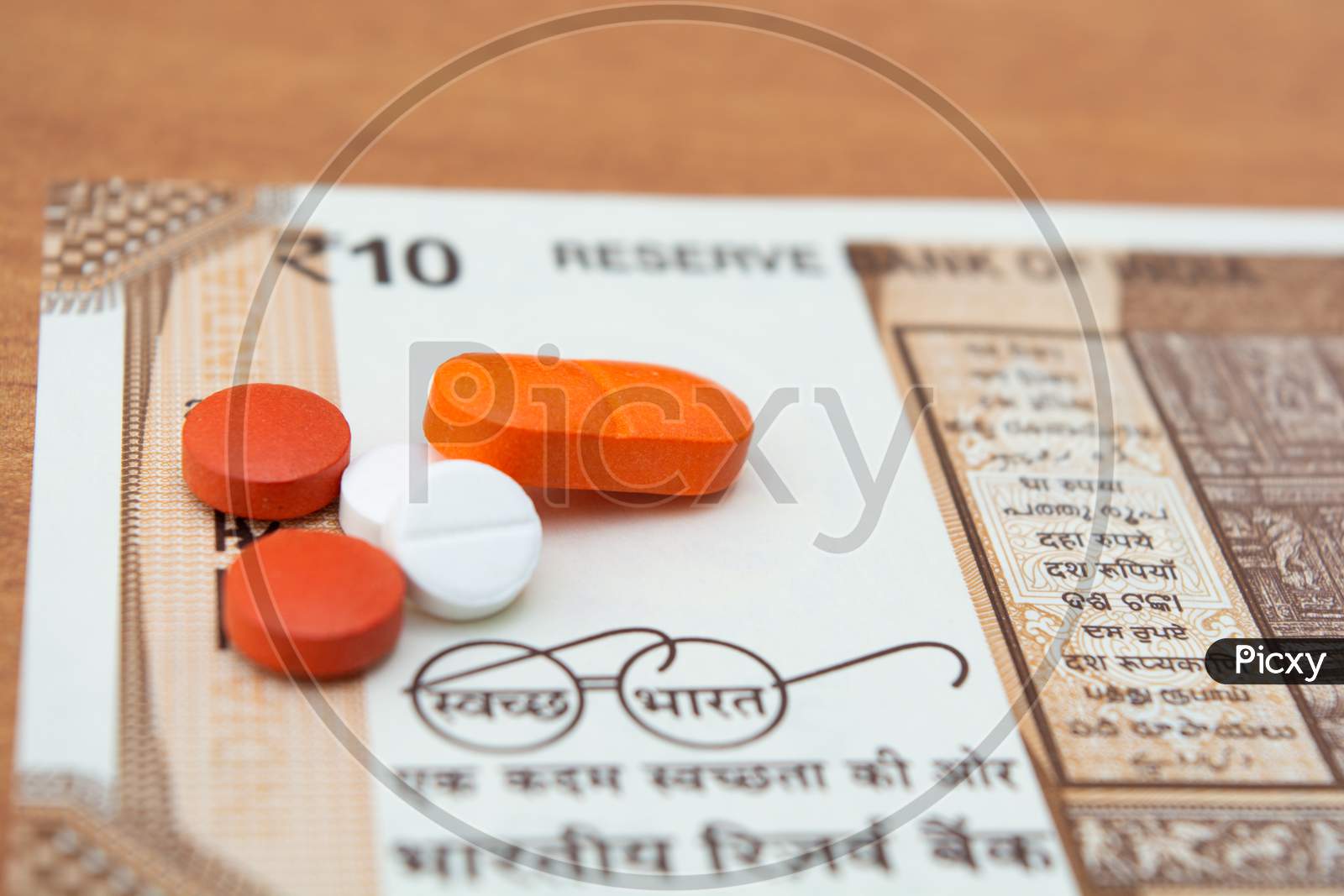 Concept Of The Affordable Medicine In India Due To Generic Drugs On Indian Currency Notes As Background.