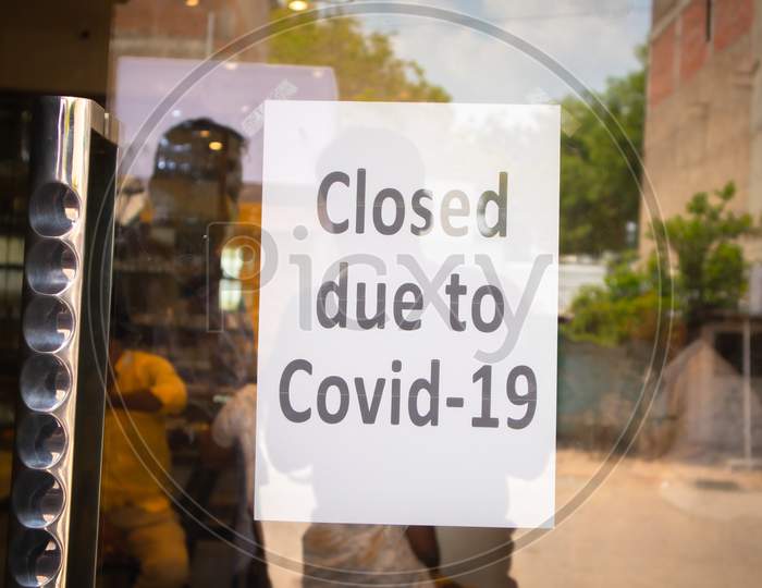 Close due to COVID-19 text on a Door at a Store