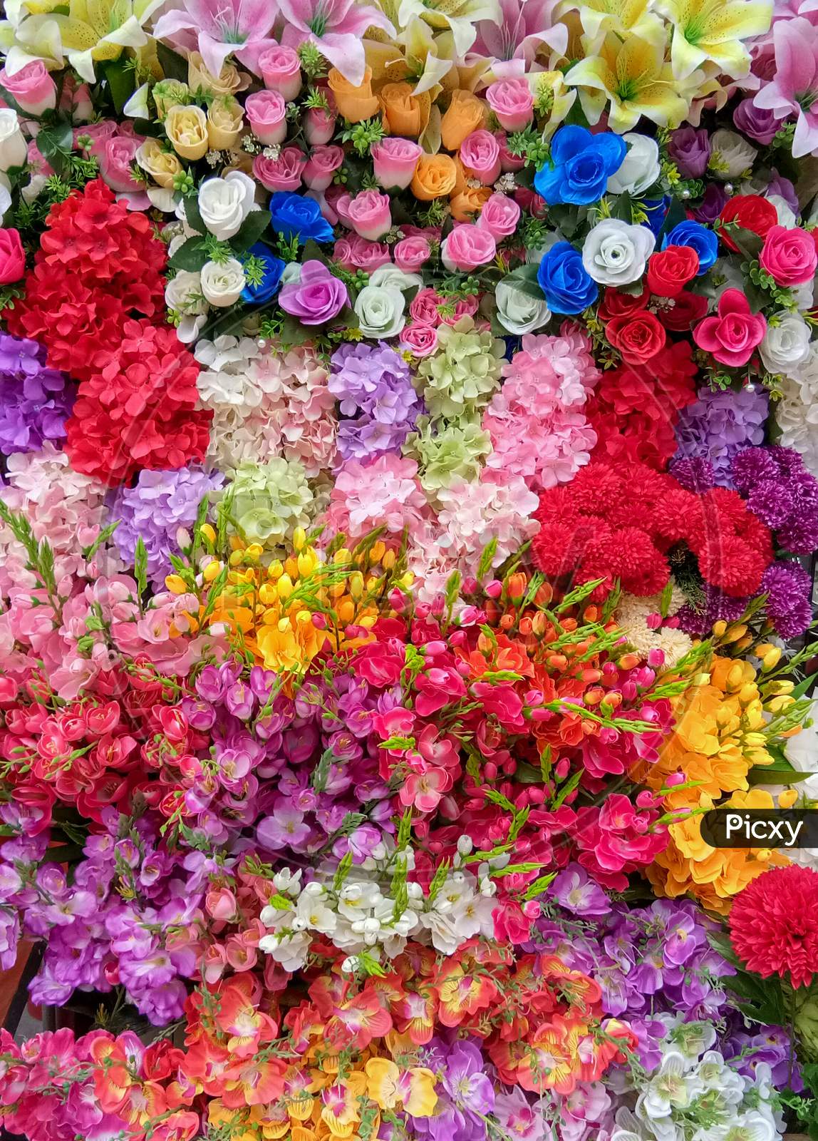 Colorful Artificial Flowers Top View Multicolor Bouquet Full Frame, Vertical Picture, Beautiful Background For Celebrate Theme.