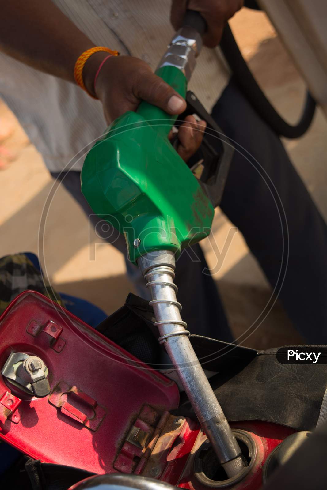 Person Filling The Petrol Using Oil Dispenser To Bike Petrol Tank Close Up.