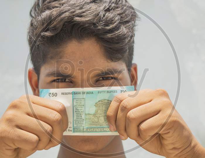 A Man Covers His Face With Bills Of Money Indian Currency