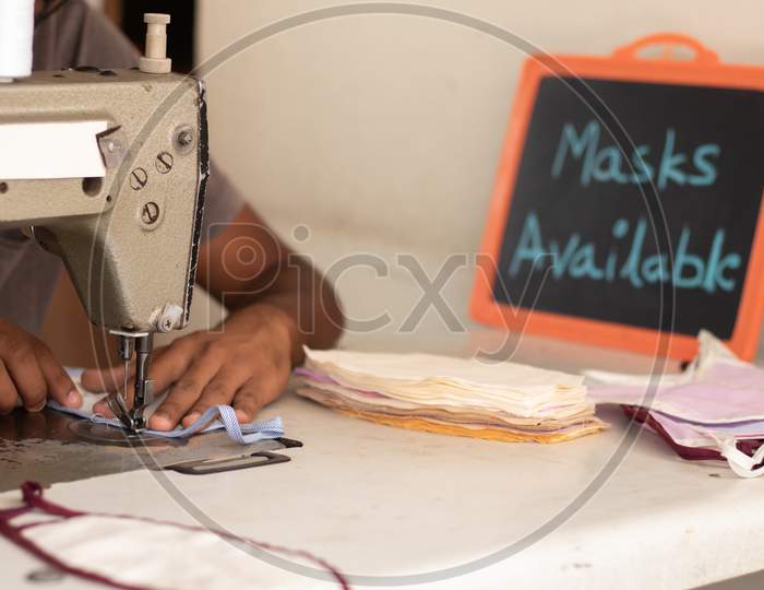 Small Business Of Mask Producing And Selling At Home In India Due Shortage Of Medical Masks During Covid-19 Or Coronavirus Pandemic - Using Sewing Machine To Sew Face Mask With Mask Available Board