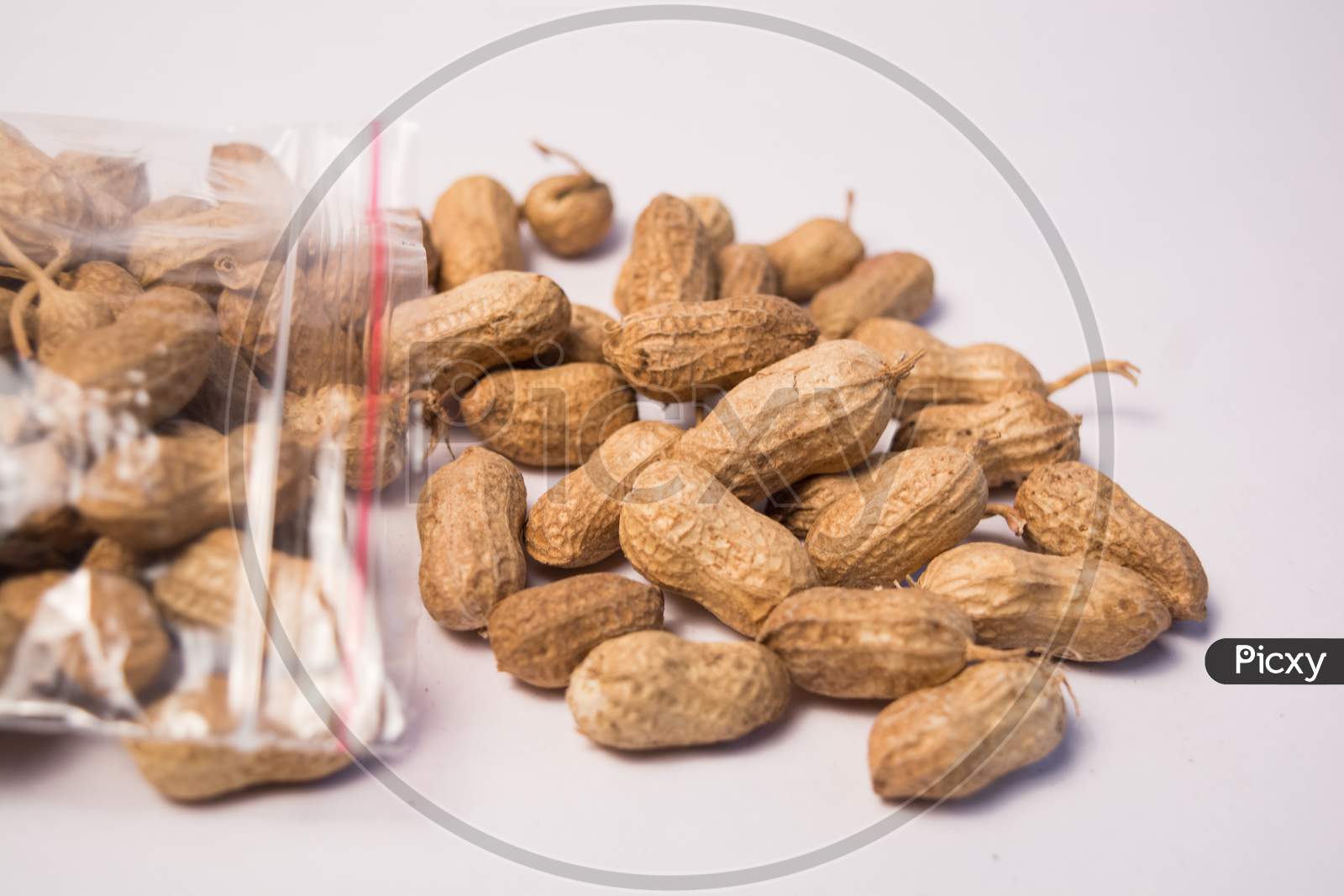 Groundnuts Or Peanuts Coming Out Of The Plastic Bag On Isolated Background