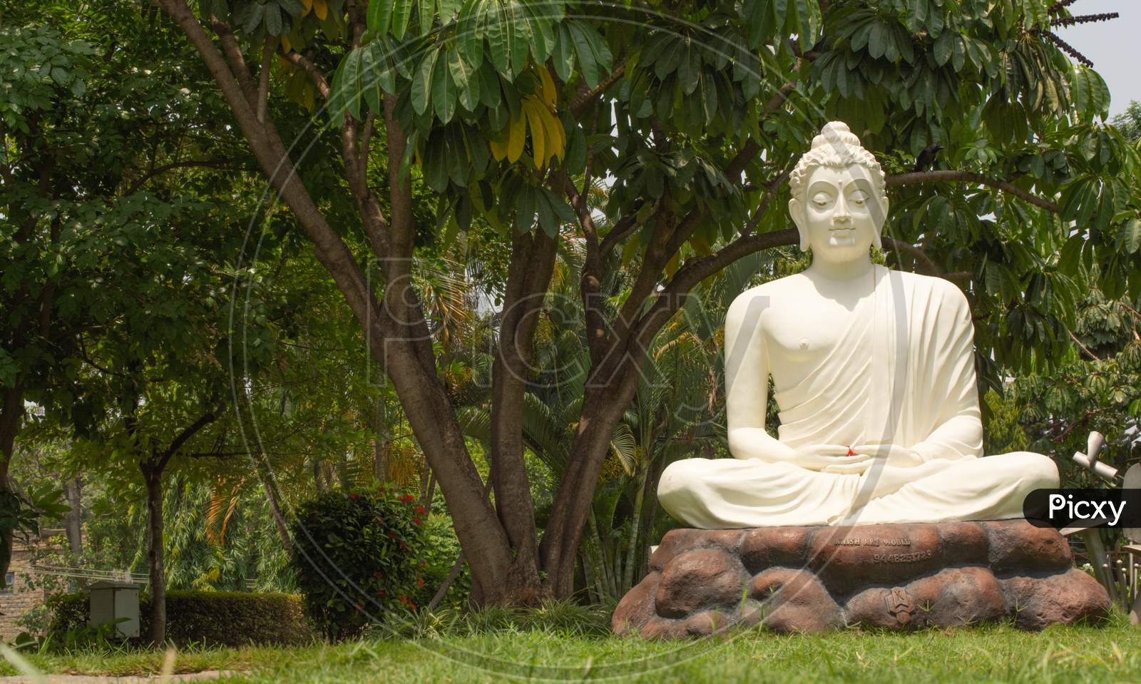 Bangalore, Karnataka India-June 04 2019 : White Buddha Statue In Meditating Posture On Stone Table With Nature As A Background