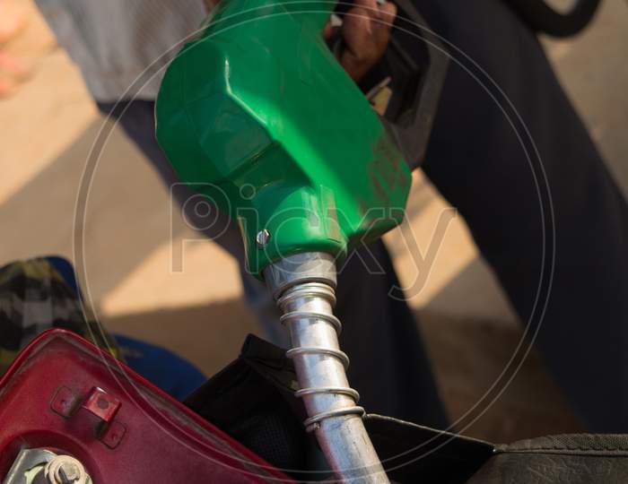 Person Filling The Petrol Using Oil Dispenser To Bike Petrol Tank Close Up.