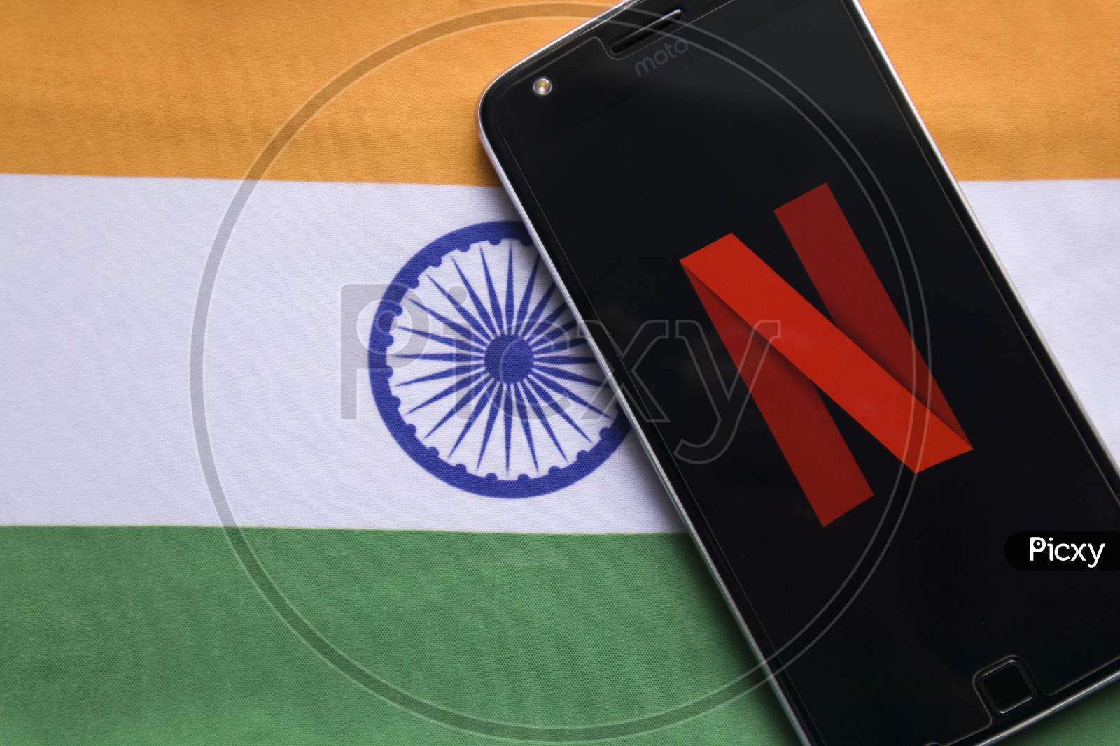 Netflix Logo On Mobile With Indian  Flag As Background.