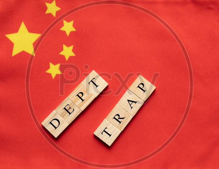 Concept Of Dept Trap In Wooden Block Letters On Chinese Flag.