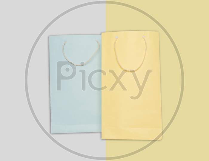 Light Blue And Yellow Color Shopping Paper Bag On Colorfull Background.