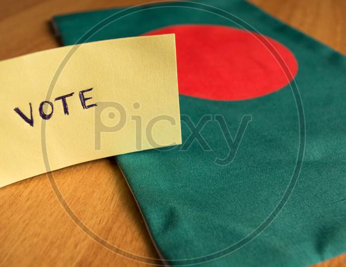 Voting Concept - Hand Written Voting Sticker On Bangladesh Flag.