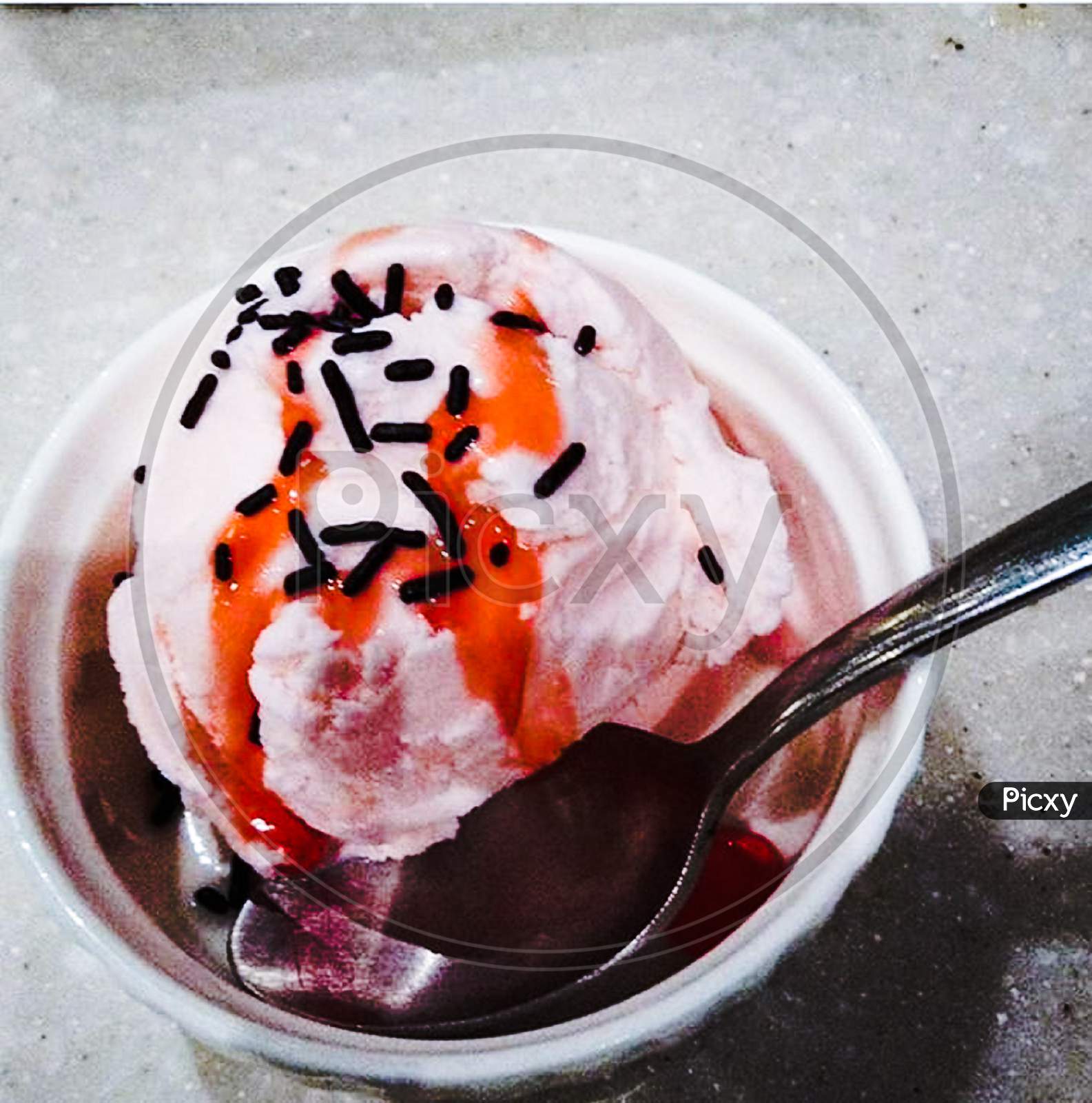ice cream with sprinkles and cherry sauce