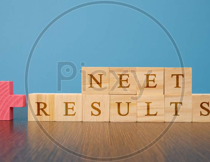 Neet Results A Medical Exam Conducted in India In Wooden Block Letters On Table.