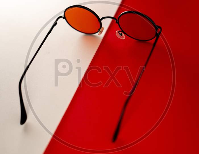 Red shaded sunglasses against a matching red and white background. A perfect gear for summer.