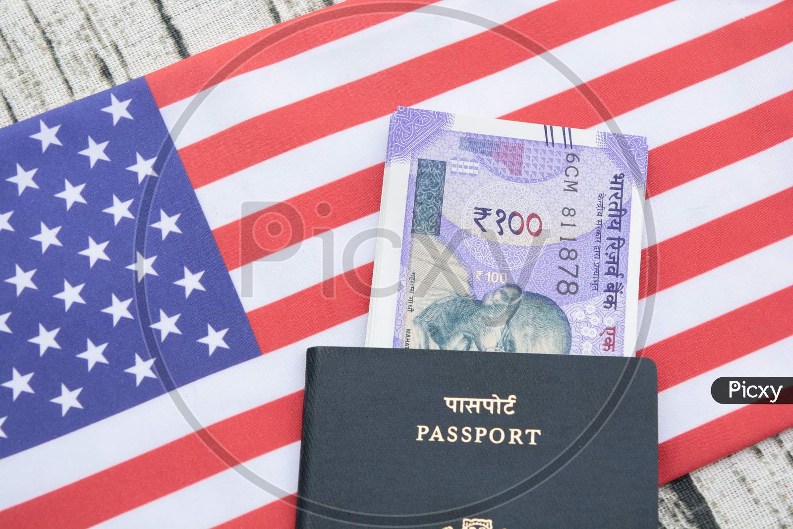 Closeup Of Indian Passport With Currency On Usa Or America'S Flag As A Background