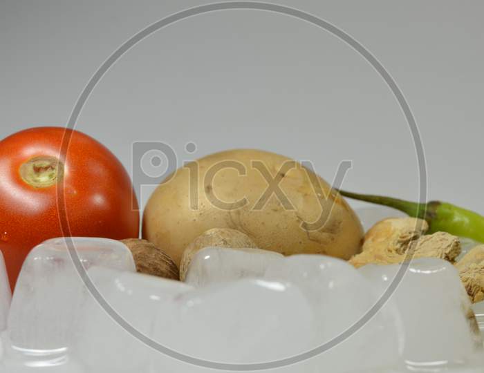 Tomato, Potato, Ginger and Chillies with the ice cubes isolated with white background