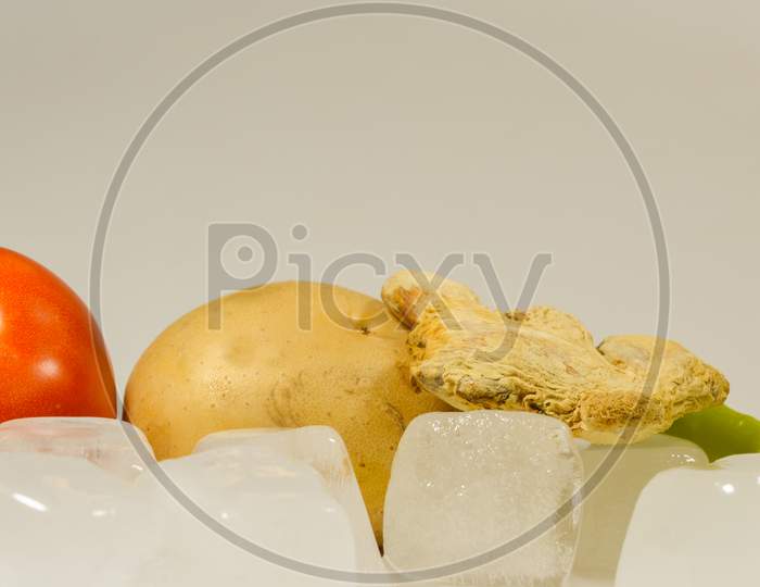 Tomato, Potato, Ginger and Chillies with the ice cubes Cubes isolated with white background