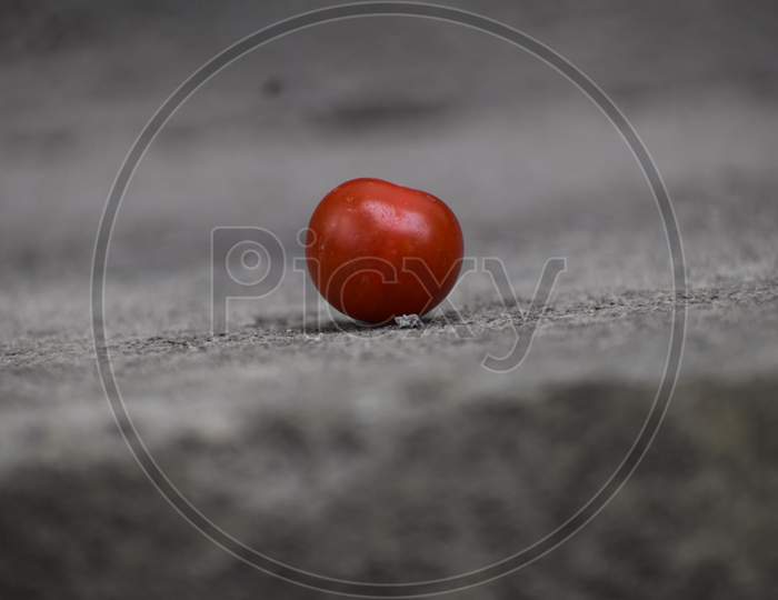 a cherry tomato is lying on the ground
