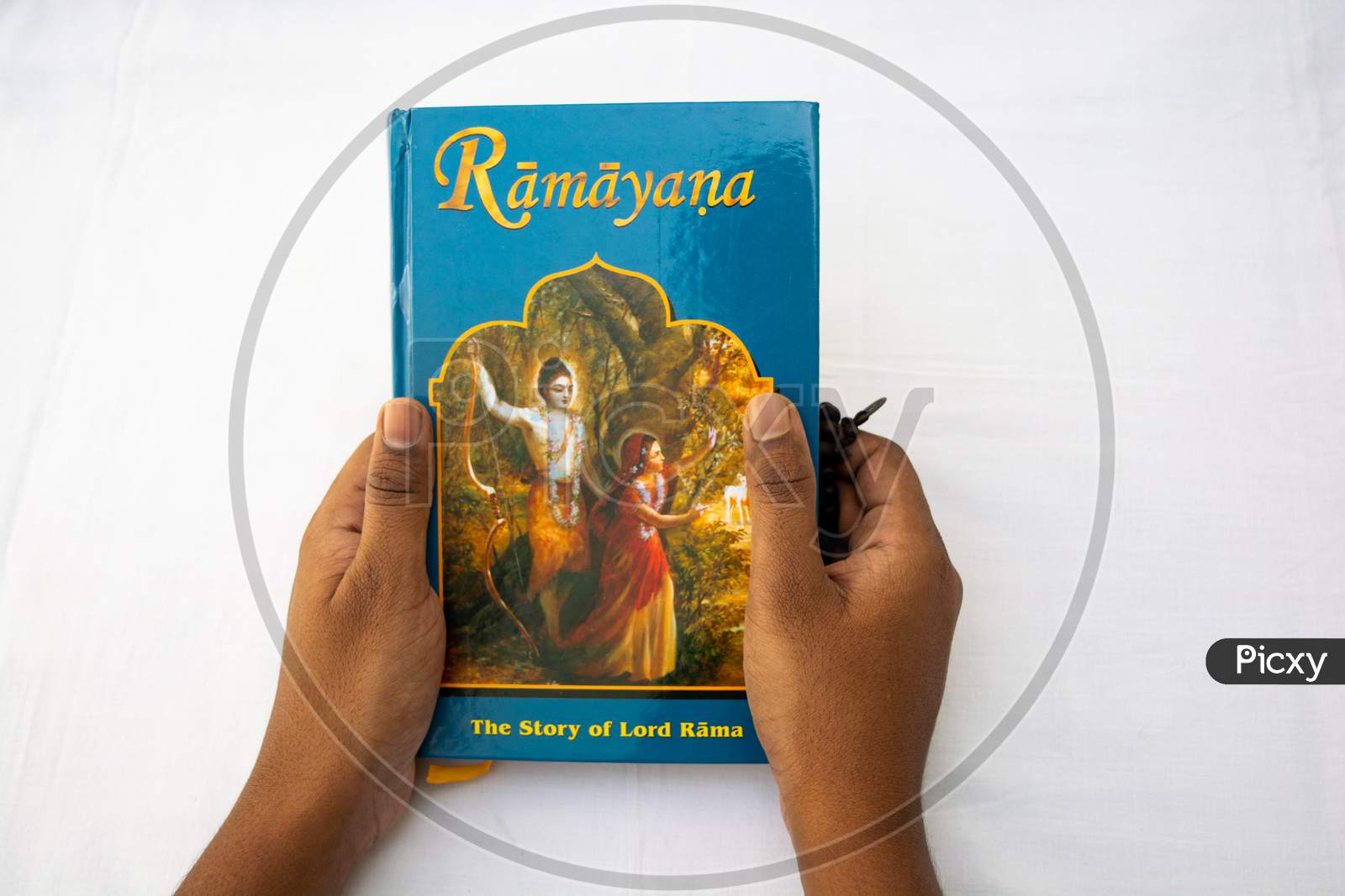 Man Holding The Epic Hindu Mythology Ramayana Book On Isolated Background.