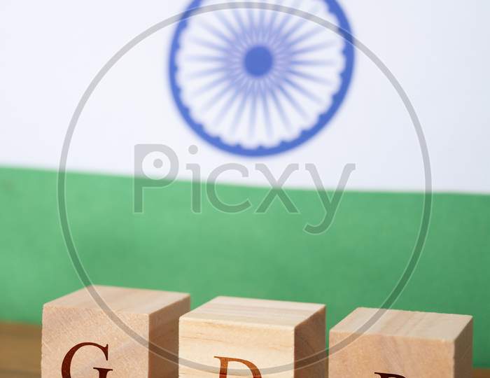 Gdp Or Gross Domestic Product In Wooden Block Letters, Indian Flag As A Background.