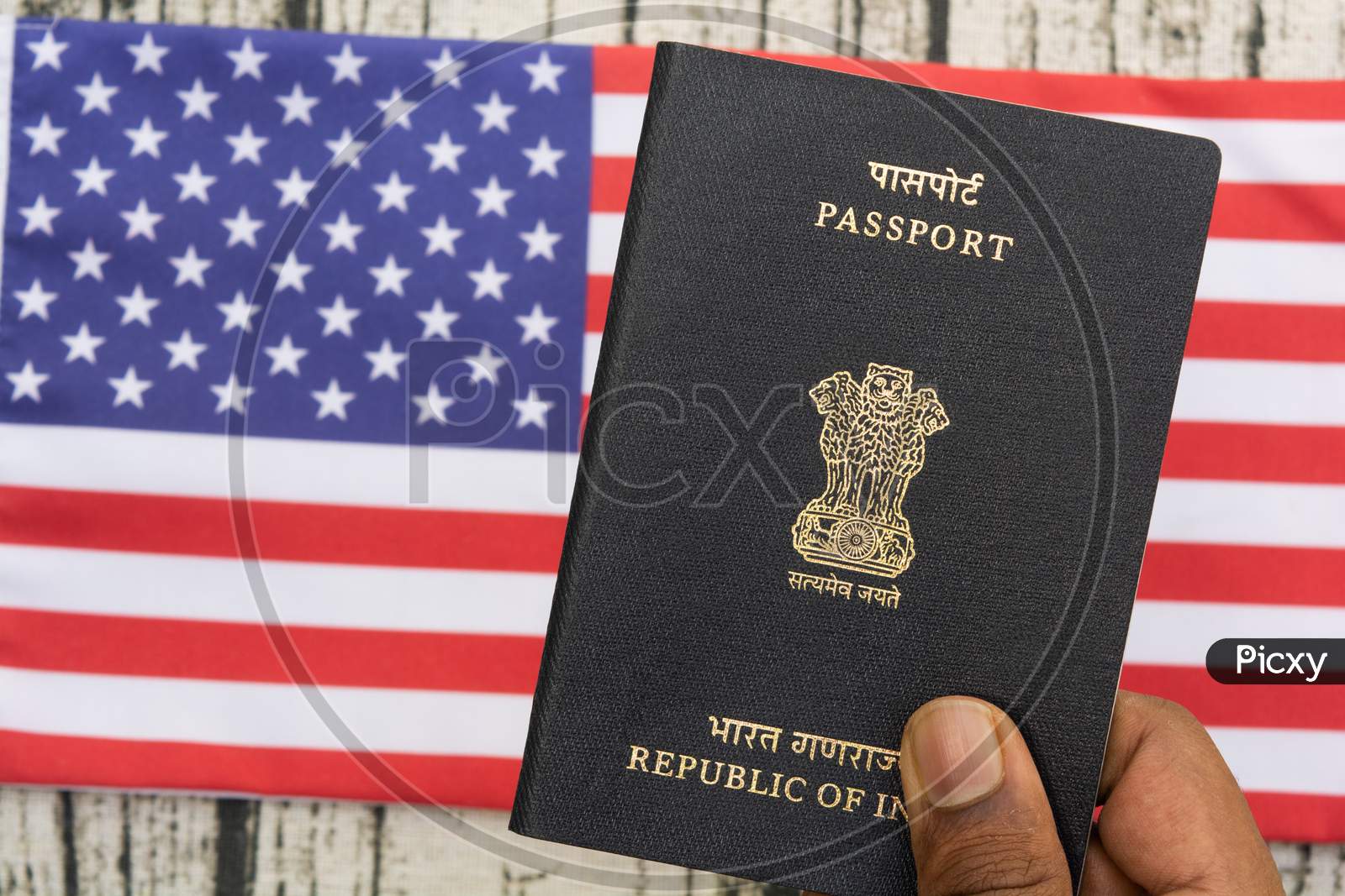 Person Holding Indian Passport With Hand On A Us Or American Flag As Background.