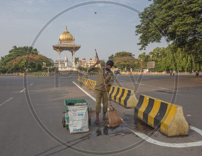 An Health worker cleaning the road near Mysore Palace
