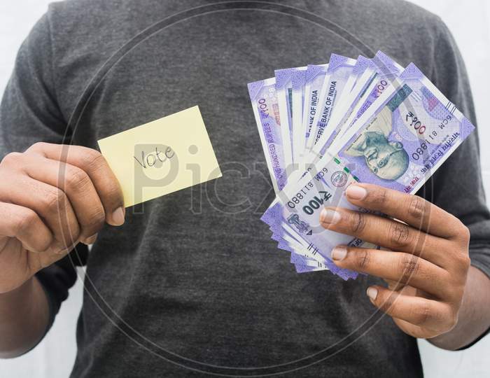 Man Holding Money And Vote Symbol In Hand, Concept Of Showing A Cash For Vote.