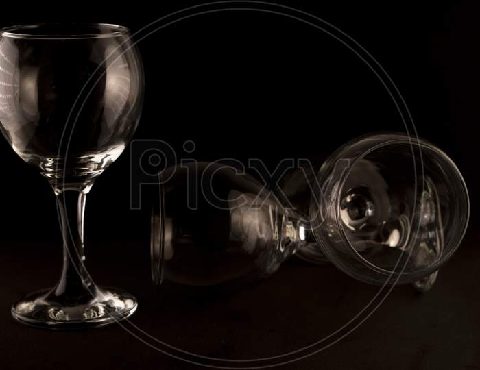 picture of empty wine glasses against a black background.