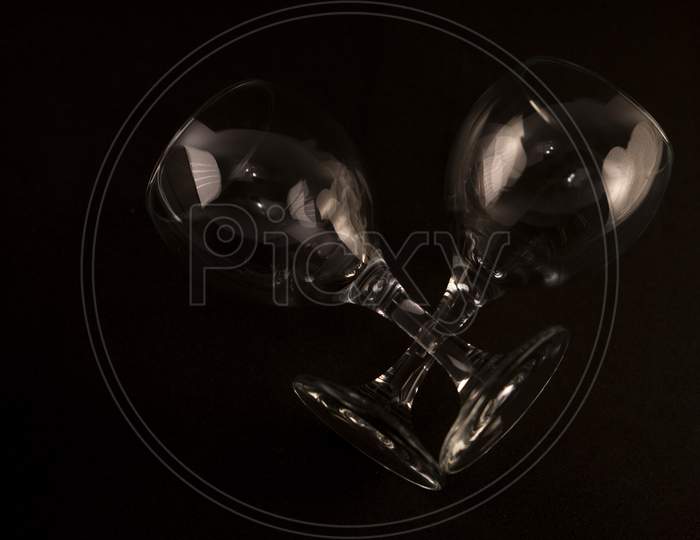 Flat-lay wine glasses over black background, top view.  Photo has empty space for text