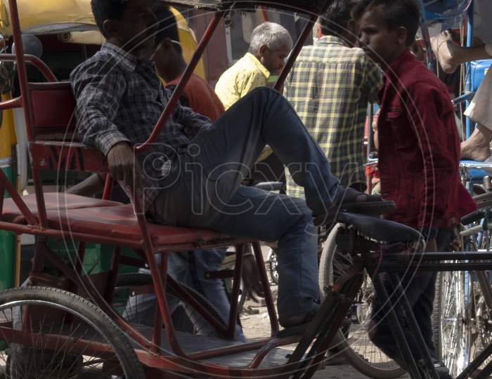 Rickshaw driver having rest on seat