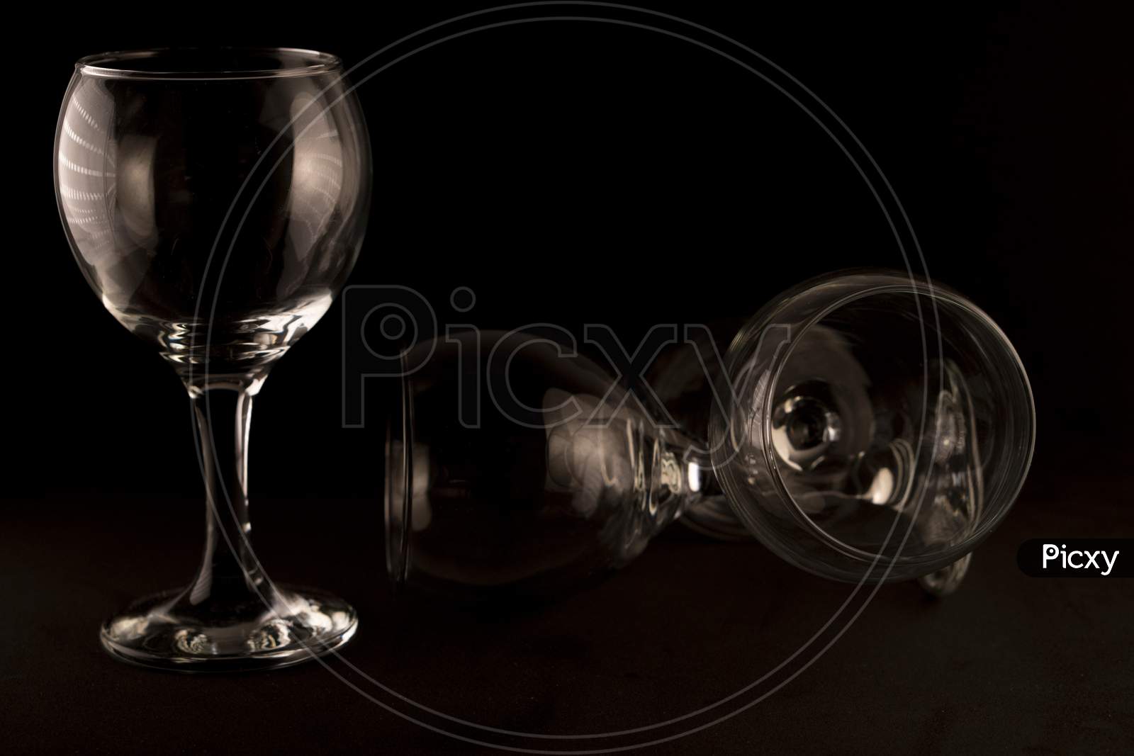 picture of empty wine glasses against a black background.