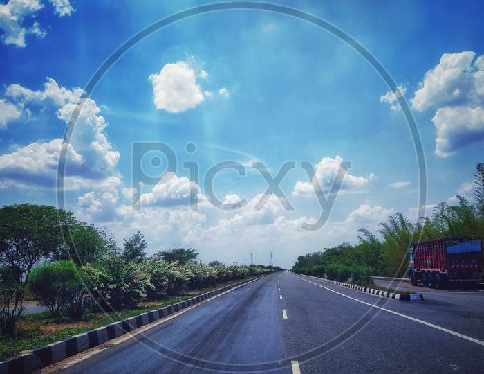 Indian highway road with beautiful greenary surrounding and cloudy sky