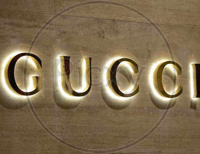 Illuminated Gucci Sign On A Marble Stone Wall