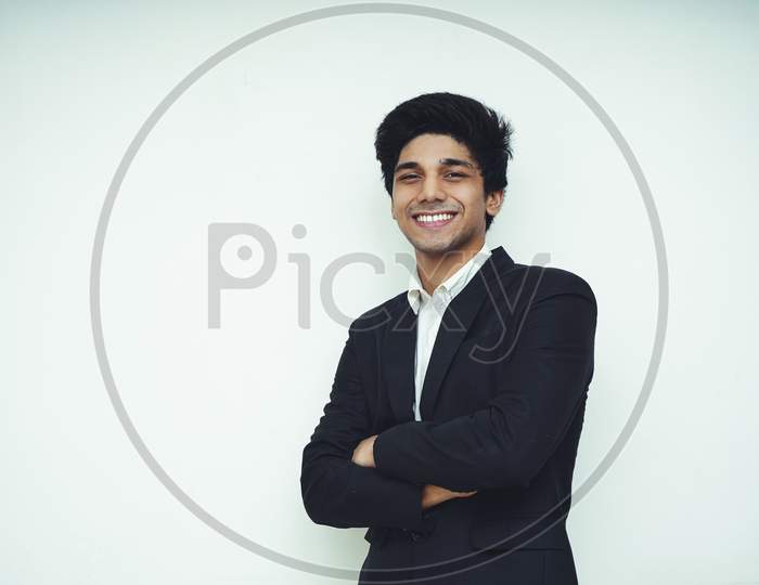 Portrait Of A Young Handsome Asian Business Man Wearing Black Coat And White Shirt Standing In Front Of A White Background, Smiling And Looking Into The Camera,