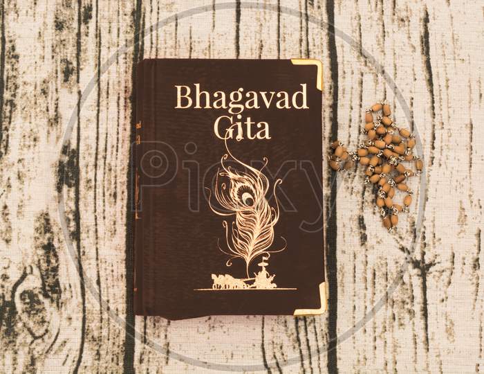 Holy Bhagavad Gita With Wooden Textured Background.