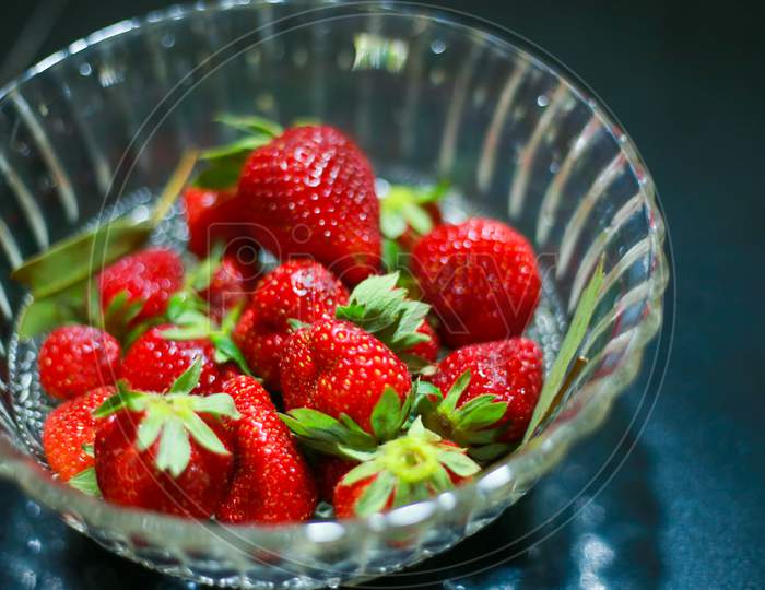Group Of Strawberry In Glass Bowl Red Colour Fruit, Strawberry In A Dark Background