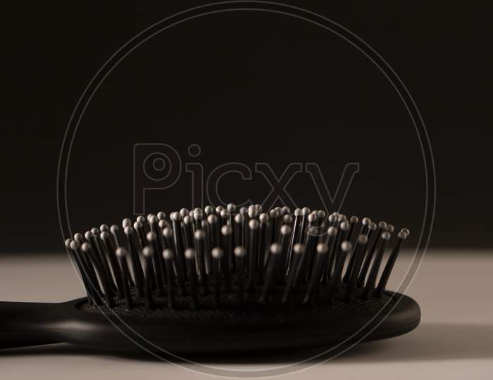 black hair brush against white and black background
