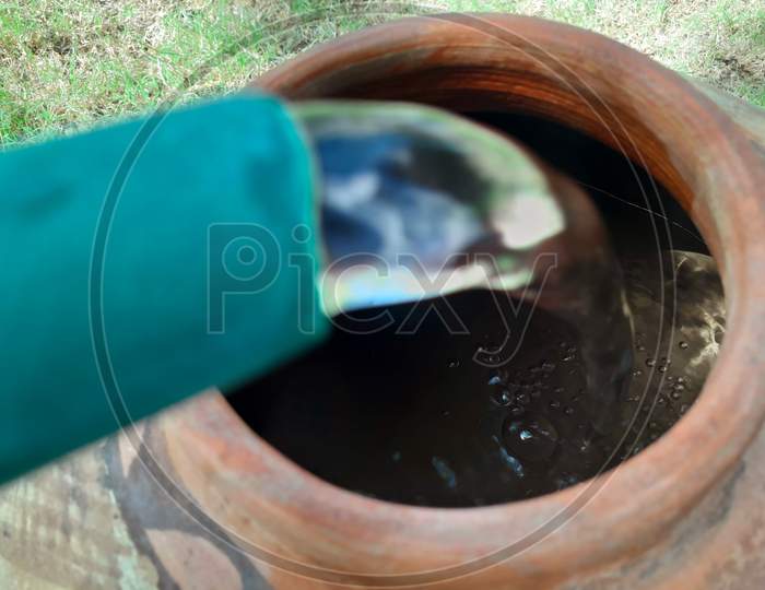 Filling Water In A Clay Pot In Summer During Lack Of Water In Rural Areas